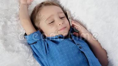 一个可爱的孩子躺在白色的沙发上，打着电话，体验着真挚的情感：快乐、幸福、欢笑